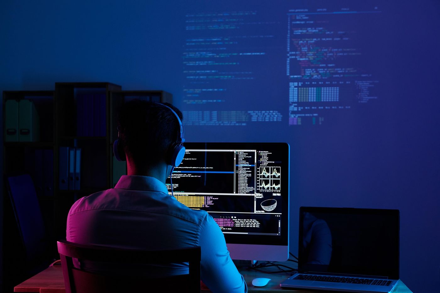 Osoba pracująca i programująca na komputerze w swoim pokoju